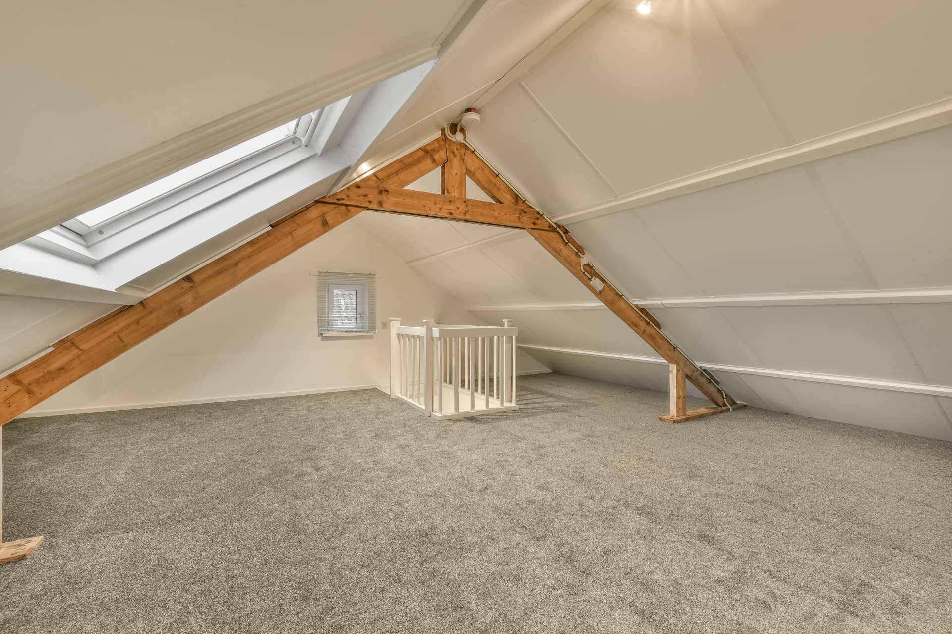 Converted loft room with skylight, exposed timber trusses and new staircase balustrade