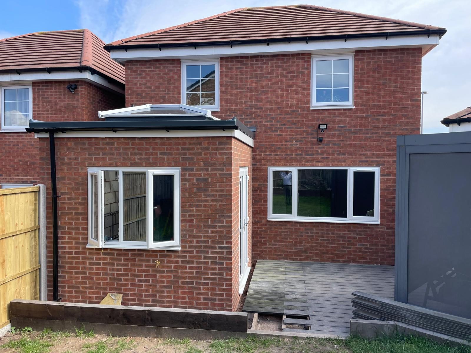 Rear exterior of a brick orangery with rooflight, windows and decking in Cannock