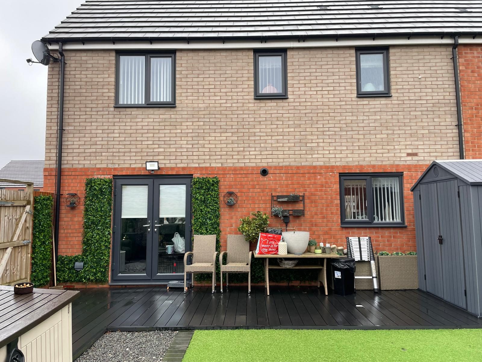 Completed rear house extension with dark French doors and garden decking in Cannock