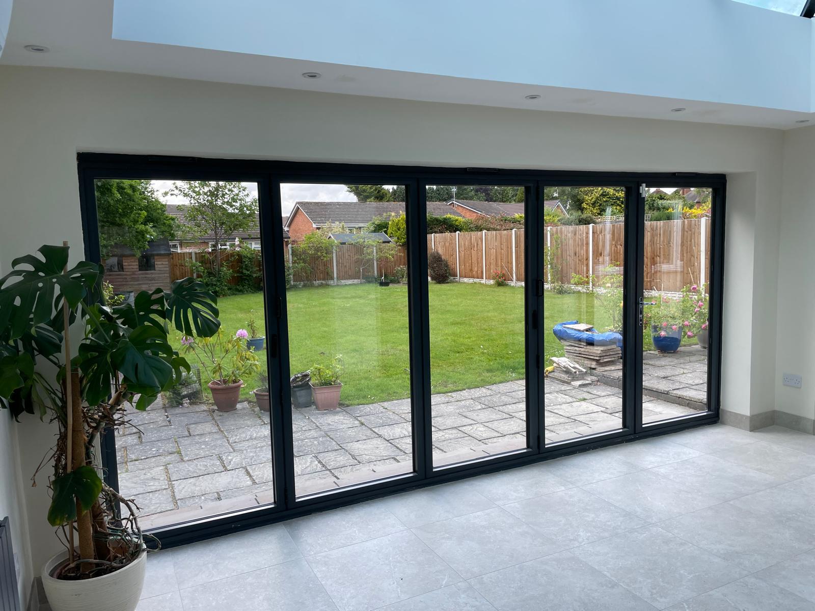Internal structural opening fitted with anthracite bi-fold doors and a roof lantern in a finished open-plan room