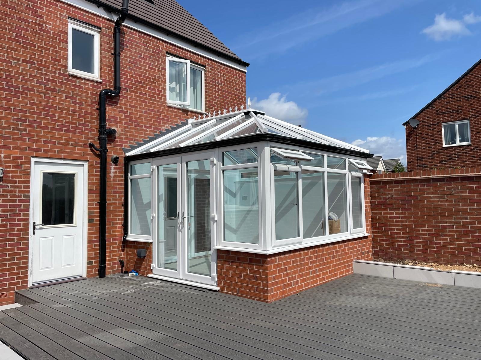 Finished conservatory with glazed roof, French doors and composite decking in Cannock